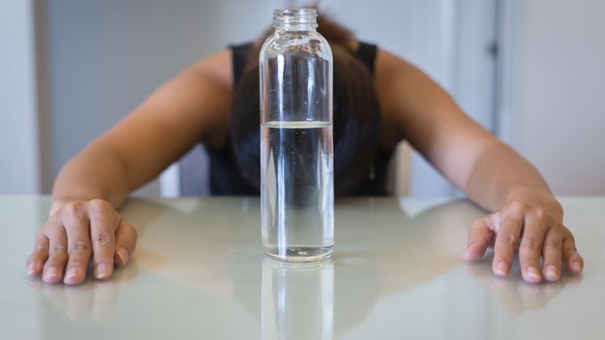 woman trying to lose weight, with a glass of water- Water Fasting
