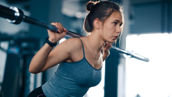 Attractive Young Sports Woman Doing Squats 