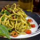 pasta-with-green-vegetable-on-white-and-black-ceramic-plate